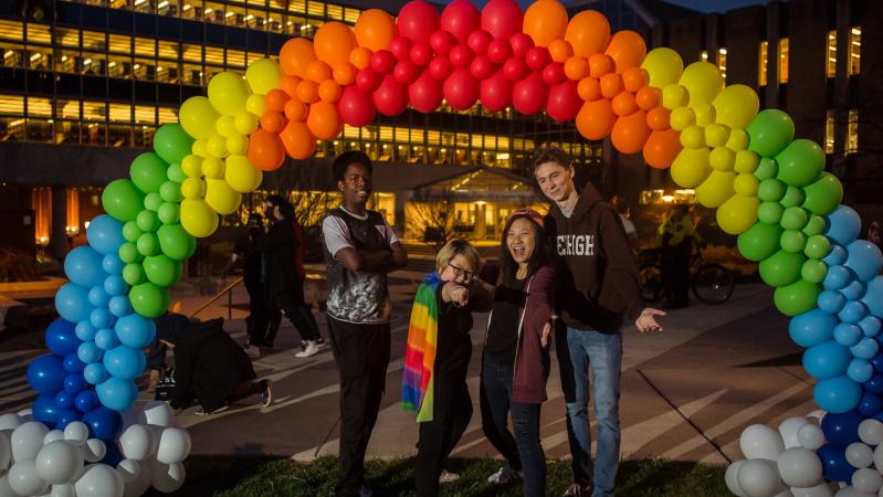 students at Pride-A-Palooza 2018 standing under a rainbow balloon arch